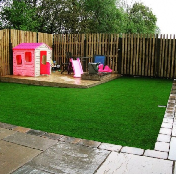 Taman dengan rumput sintetis dan taman bermain anak